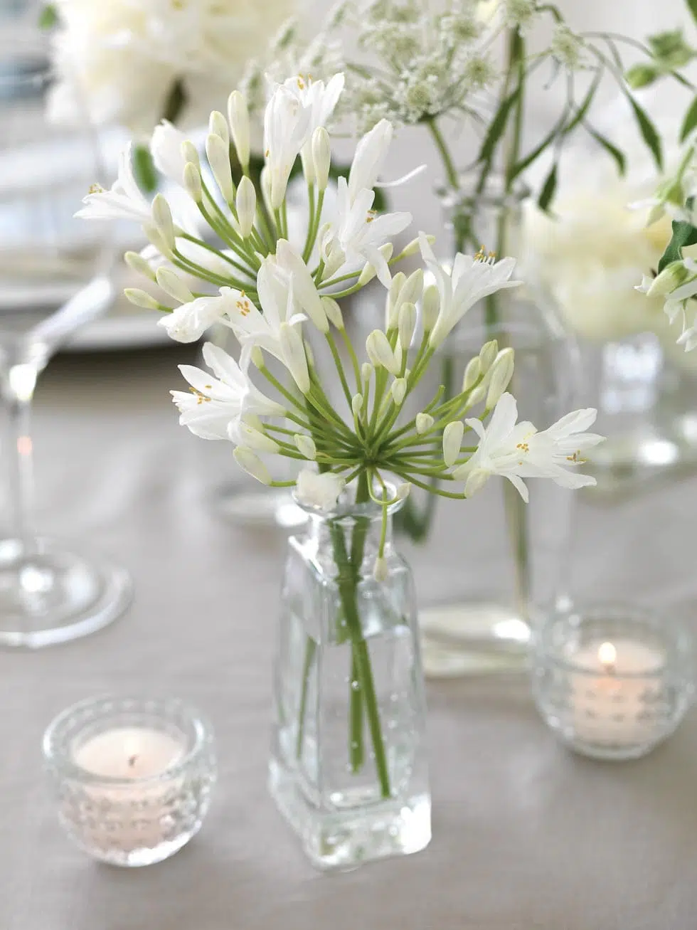 Tischdeko mit Blumen in Flaschen